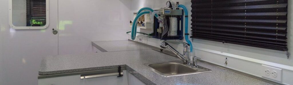 Interior of a modern mobile laboratory with a sink and specialized equipment.